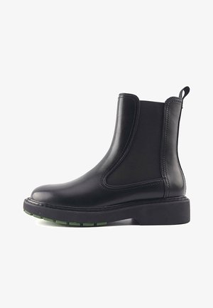 Juodi odiniai auliniai batai iki kulkšnies su elastinėmis šoninėmis plokštėmis, apvaliu priekiu ir masyviu juodu padu su žaliais akcentais. Lygi tekstūra, tvirtas dizainas.