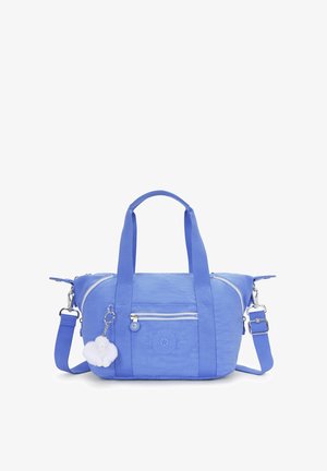 Sac à main en tissu synthétique bleu avec de courtes poignées, une bandoulière amovible, une poche zippée à l'avant et un charme en pompon blanc attaché.