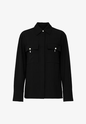 Camicia nera a maniche lunghe con colletto, due tasche sul petto con bottoni a perla e vestibilità dritta. Tessuto dalla texture liscia, design minimalista.