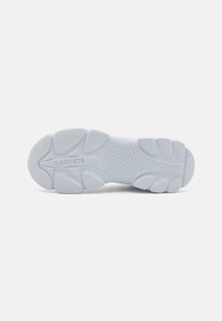 Suela de zapatilla Lacoste en goma blanca; con un patrón texturizado y un dibujo en zigzag para proporcionar tracción; logo en relieve en la media suela.