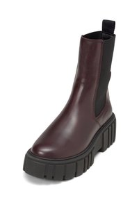 Stivale ankle in pelle borgogna con pannelli laterali elasticizzati, punta rotonda e resistente suola in gomma nera spessa con scanalature orizzontali.