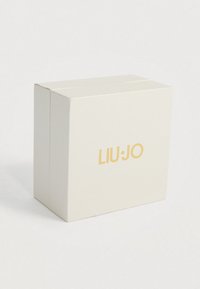 Scatola bianca texturizzata con logo dorato "LIU·JO", caratterizzata da un design quadrato e una finitura pulita.