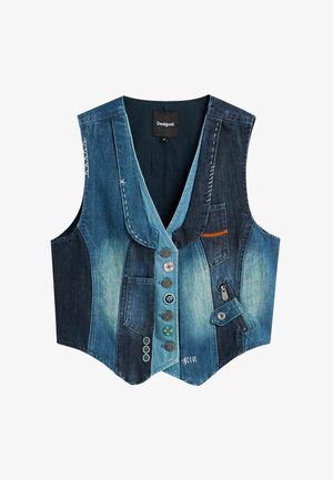 Teksapikendiga teksapikitud vest, millel on V-kaelus, vahelduvad heledad ja tumedad sinised panelid, mitmed dekoratiivsed nupud, õmblusdetailid, taskud ja külgmist lukku.