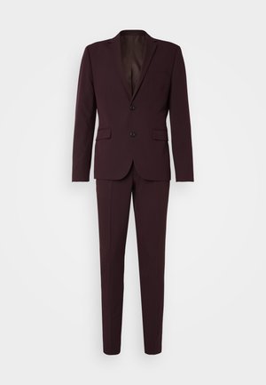 Costume bordeaux foncé avec une veste à bouton unique comportant deux boutons, des revers crantés et un pantalon à plat. Fabriqué en tissu lisse.