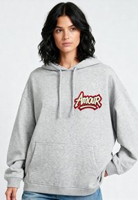 Felpa grigia con un grande logo ricamato "Amour" in rosso e nero sul petto. Presenta un cappuccio con cordino e una tasca frontale.