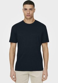Navy blue cotton t-shirt with a round neckline, short sleeves, and a relaxed fit. Minimal design with no visible patterns or logos.