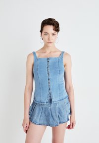 Denim mouwloos shirt met een vierkante halslijn, voorzien van een frontale knoopsluiting en verticale naden, gecombineerd met een geplooide denimrok.