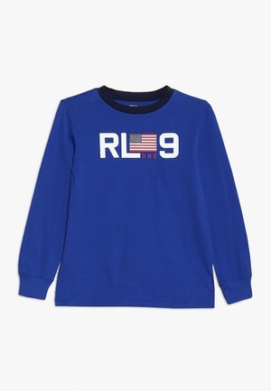 Blauw shirt met lange mouwen en zwarte kraag met de tekst "RL 9" en een kleine Amerikaanse vlag tussen de letters.