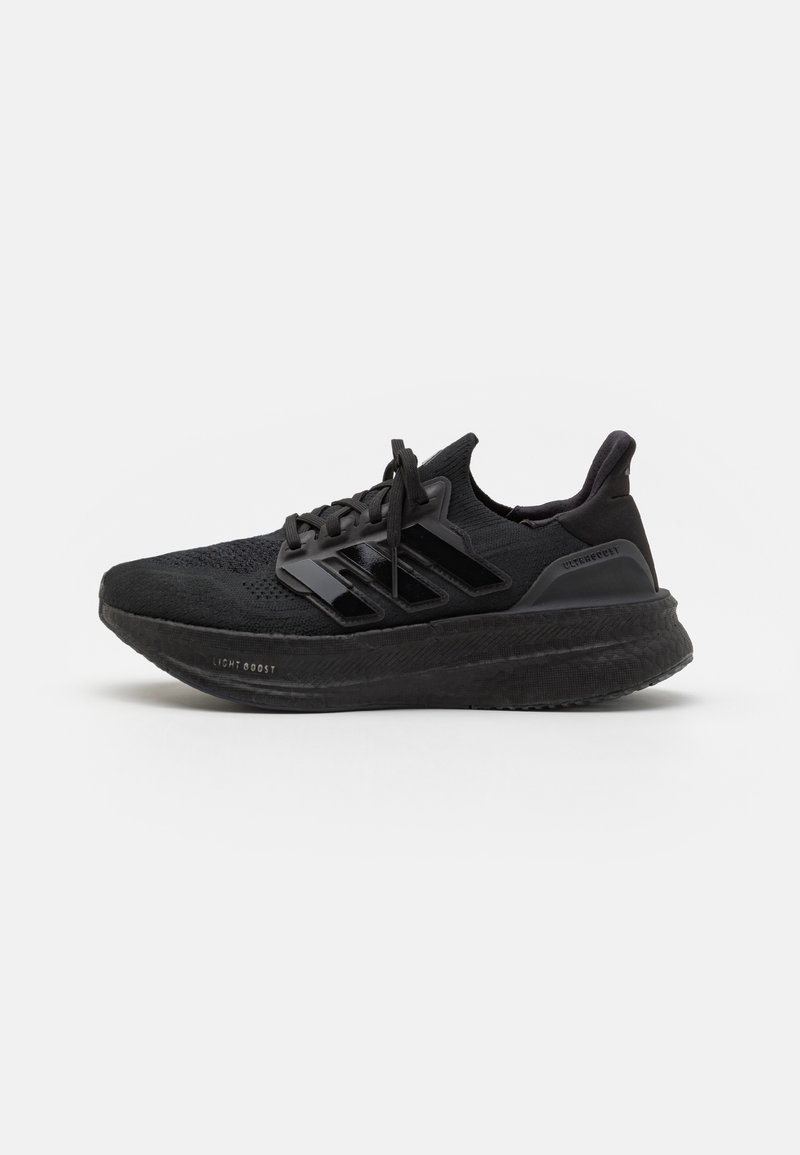 Chaussures de sport noires avec une tige en tricot texturé, trois bandes brillantes, semelle en mousse légère et talon renforcé. Présente un design à lacets.