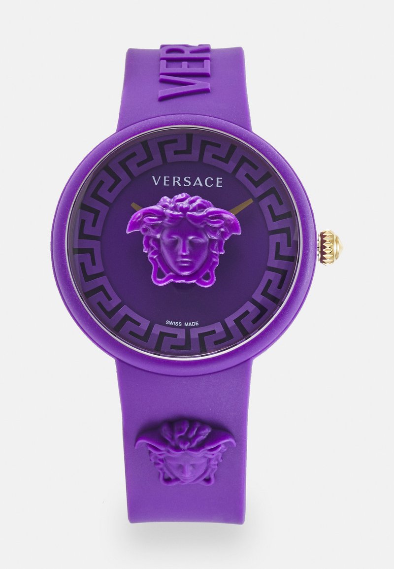 Orologio in silicone viola con una prominente testa di Medusa, lunetta con motivo nero, dettagli dorati sulle lancette e testo "VERSACE" sul quadrante.
