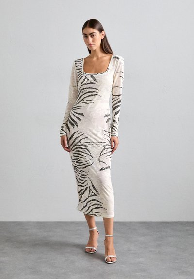 Langärmliges, figurbetontes Kleid in Creme mit einem schwarzen Zebra-Streifen-Muster, gefertigt aus einem weichen, strukturierten Stoff, mit einem quadratischen Ausschnitt.
