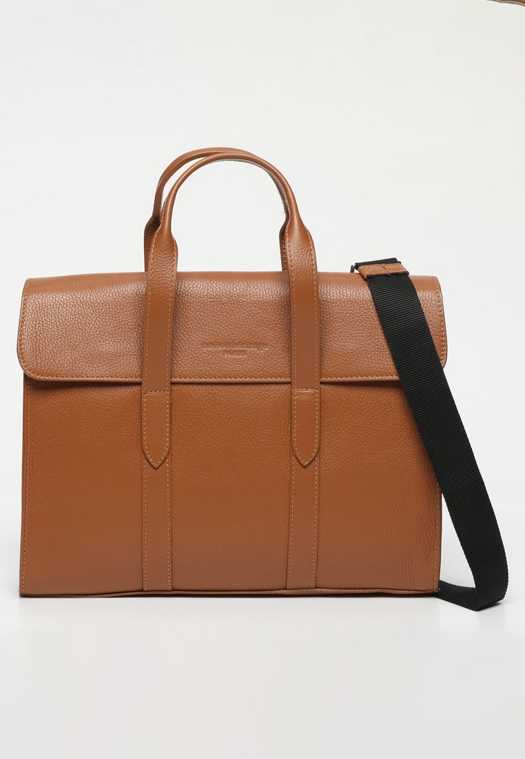 Sac messager en cuir marron avec une finition texturée, deux poignées supérieures et une bandoulière en tissu noir détachable. Forme rectangulaire standard.