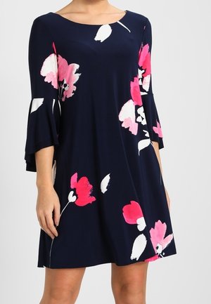 Marineblå kjole med store lyserøde og hvide blomsterprint, med trekvart lange klokkeærmer og rund halsudskæring.