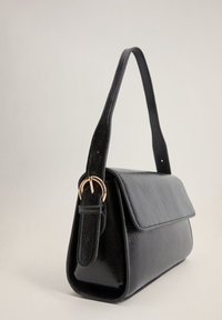 Mustaksi keinonahasta valmistettu käsilaukku, jossa on suorakulmion muotoinen rakenne, taitettava läppä ja kultasävyinen solki hihnassa. Sujuva pinta, minimalistinen muotoilu.
