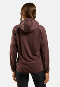 Haut à capuche bordeaux avec un corps texturé, des manches lisses et une capuche resserrée. Il présente un ourlet droit et des détails de couture subtils.