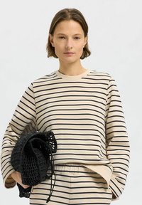 Beige a černý pruhovaný svetr s dlouhým rukávem, z bavlněného materiálu, s kulatým výstřihem, doplněný texturovanou černou háčkovanou taškou.