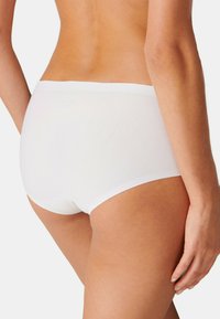 Vita bomullstrosor med en slät textur, låg midja och minimalistisk design, med rena linjer och ett elastiskt midjeband.