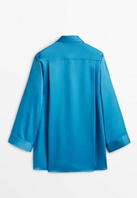 Turkusowa satynowa bluzka z kołnierzykiem, długimi rękawami i luźnym krojem. Gładka tekstura i eleganckie wykończenie z plisą z tyłu dla dodatkowego detalu.