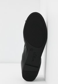 Semelle de chaussure synthétique noire avec un grip texturé, forme arrondie et un branding minimal. Taille 37 indiquée au fond.