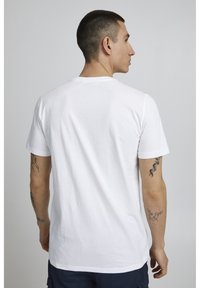 Hvid bomulds T-shirt med rund hals, korte ærmer og en afslappet pasform, der har en glat tekstur og ingen synlige mønstre eller grafik.