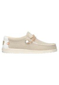 Zapatos tipo slip-on de textil beige con textura trenzada, suela de goma color crema y un cordón decorativo con un detalle de cuenta de madera. Presenta el logotipo en el costado.