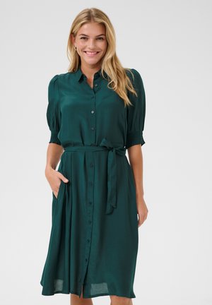 Teal knielange jurk met korte pofmouwen, een ceintuur in de taille, zijzakken en een vloeiende rok. Gladde stof met een lichte glans.