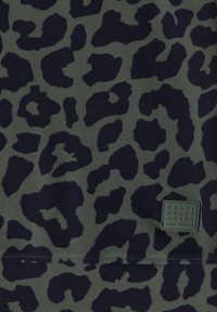 Tissu gris foncé avec motif léopard noir et une petite étiquette carrée cousue portant la mention "CHASE THE PULSE."