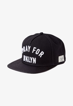 Czarna czapka typu snapback z białym haftowanym napisem "PRAY FOR BKLYN" oraz małą etykietą "Cayler & Sons" z boku.