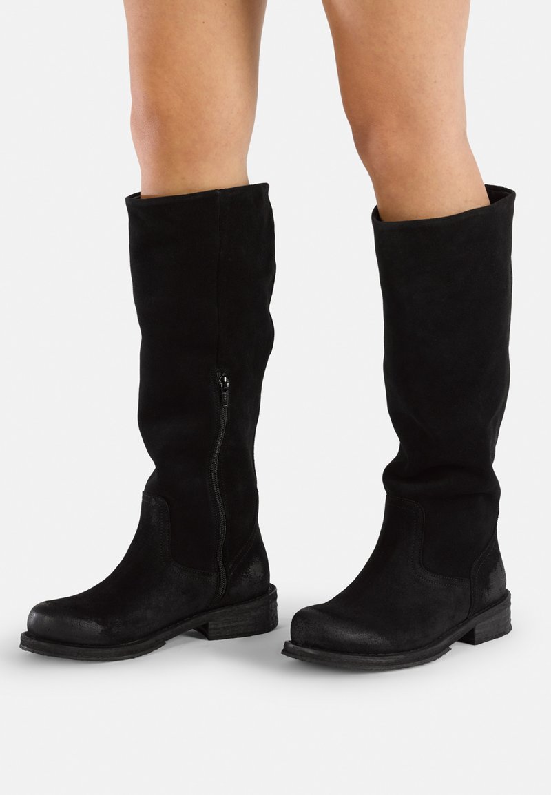 Bottes noires montantes en daim souple avec une finition lisse, dotées d'une fermeture éclair sur le côté et d'un petit talon texturé.