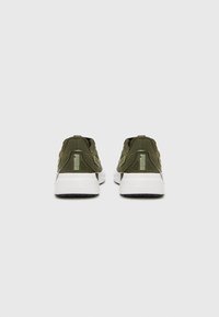 Green athletic shoes with a textured fabric upper, white rubber sole, and heel tab feature. Includes logo accent on the heel.