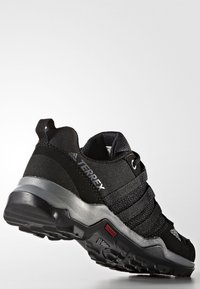 Czarne buty sportowe z teksturowaną siateczką, elastycznymi paskami i amortyzowaną podeszwą. Posiadają srebrny akcent i solidny bieżnik.