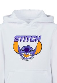 Sudadera blanca con un gráfico colorido de un personaje de dibujos animados con acentos en púrpura y naranja, texto "STITCH" arriba y "EXPERIMENT 626" abajo.
