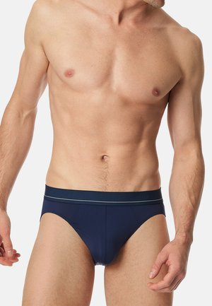 Marineblaue Unterhose aus glattem Stoff, mit einem Bund mit Logo und dünnen kontrastierenden Streifen. Enganliegendes Design, leichtes Material.