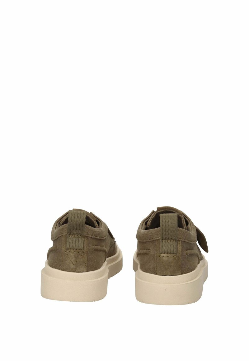 Pa paire de chaussures décontractées vert olive avec des semelles blanches épaisses, vue de dos, sur fond blanc.