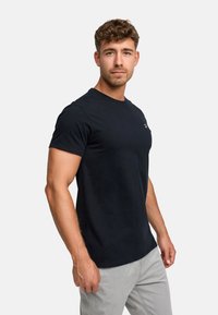 Black short-sleeve t-shirt made of cotton with a crew neckline and a small logo on the left chest. Smooth texture, fitted design.
