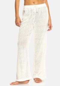 Witte, lichte, geweven broek met een losse pasvorm, voorzien van een trekkoord in de taille en een gestructureerd open patroon.