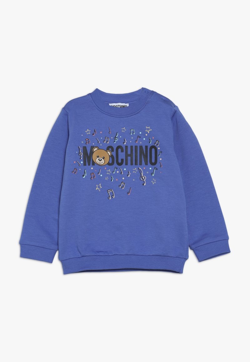 Blå barntröja med "Moschino"-text, ett teddy-björnsansikte och färgglada musiknoter och stjärnor på framsidan.