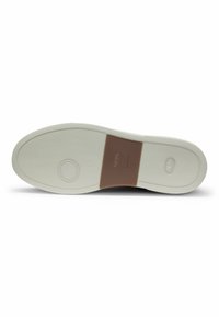 Shoe sole with a textured rubber design, featuring a white color with a brown accent in the center and a circular logo detail.
