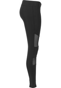 Leggings neri realizzati in materiale elasticizzato, con inserti in rete trasparente ai lati per un tocco di design e una maggiore traspirabilità.