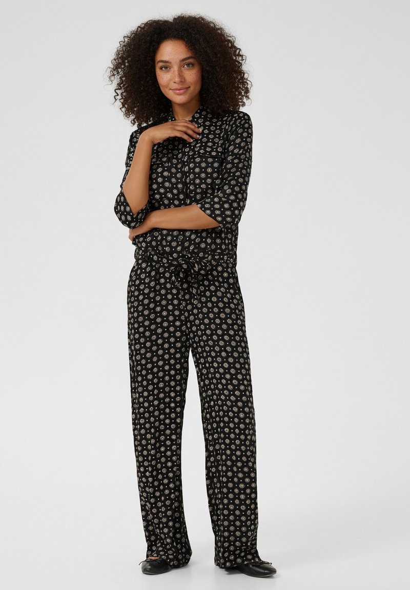 Schwarzes Pyjama-Set mit floralem Muster, bestehend aus einer Knopfleiste oben und einer Hose mit Kordelzug, bietet eine lockere Passform und leichtes Gewebe.