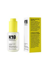 K18 moleculaire herstellende haarolie in een witte matglazen fles met een felgele dop. Vergezeld van een geel en witte kartonnen doos.