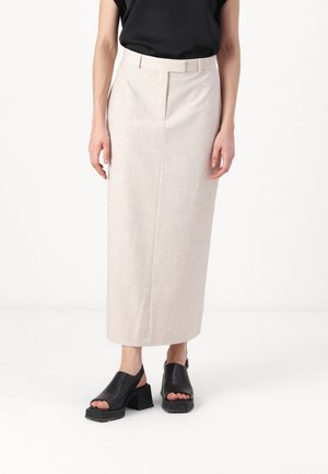 Hame beige vaalea, midi-pituisilla suoralinjaisilla leikkauksilla ja hienovaraisella tekstuurilla. Yhdistetty mustiin avonaisiin kengissä, joissa on paksut korot.