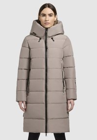 Beige puffer coat with a hood, featuring horizontal quilted design, front zipper closure, and side pockets with black zippers.