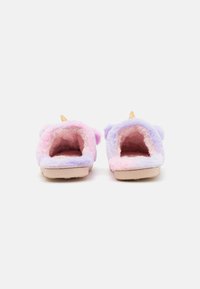 Zapatillas difusas en tonos pastel rosa y púrpura con una textura esponjosa, que presentan orejas elevadas y un pequeño cuerno dorado en la parte superior. Suelas planas.