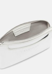 Biała skórzana portfel z zamkiem błyskawicznym, o gładkiej fakturze i subtelnym wytłoczonym logo; wnętrze wykończone jasnym materiałem.