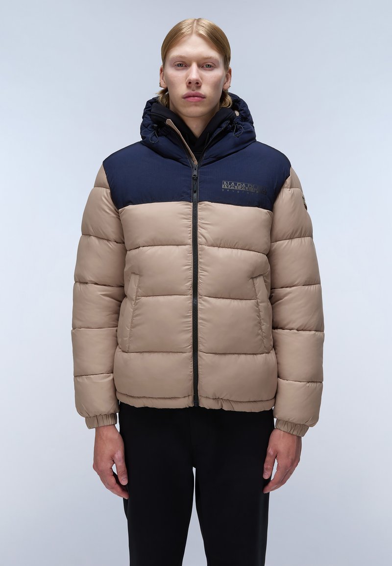 Giubbotto imbottito in beige e blu navy, con zip frontale, cappuccio e polsini elasticizzati. Realizzato in materiale imbottito con un design trapuntato.