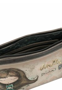 Make-up-Tasche mit Reißverschluss und beigem Außenmaterial, die eine illustrierte Abbildung eines Mädchens zeigt, mit geprägtem Text "Amelie" und "Träume" sowie mehreren Innenfächern.