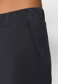 Μαύρο βαμβακερό παντελόνι φόρμας με λεία υφή, ελαστική μέση και πλαϊνές τσέπες. Το ύφασμα είναι μαλακό και ανθεκτικό, κατάλληλο για καθημερινή χρήση.