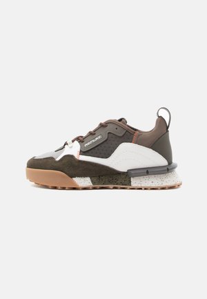 Sneakers with a mix of brown, white, and green materials; features a textured upper, lace-up closure, and patterned sole.