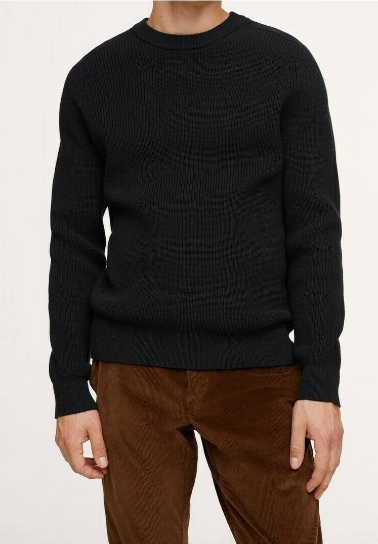 Pull en maille côtelée noir à manches longues et col rond, associé à un pantalon en velours côtelé marron, avec un tissu texturé.